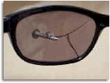 Image of a screw imbedded in a pair of sunglasses by an edger.