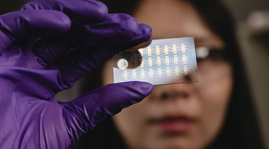 Graduate student Ke Chen holds a device for computer vision that mimics how retinal cells perceive light.